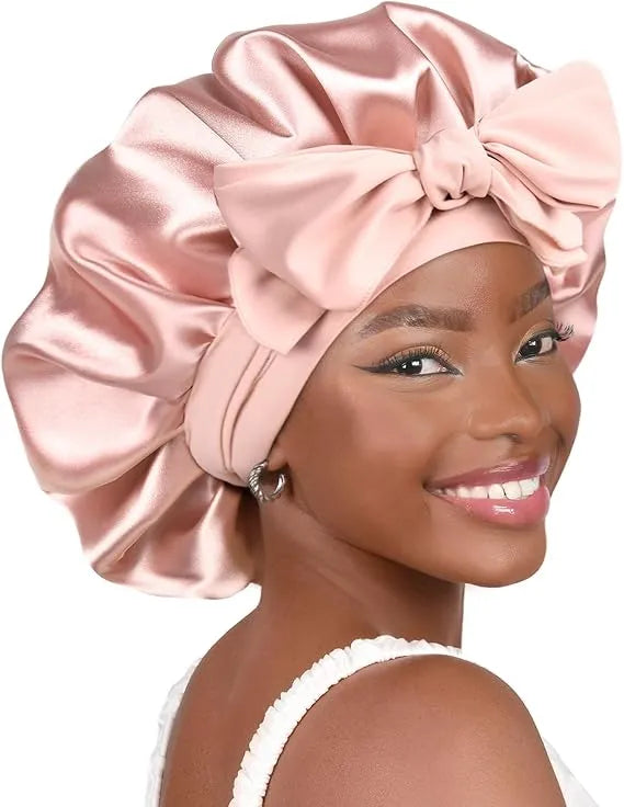 Bonnet en satin rose portĂ© avec nĆud â bonnet de nuit pour protĂ©ger les cheveux